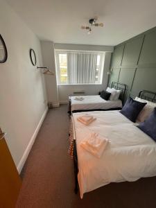 a room with two beds and a window at Electra house in Swindon