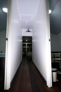 un pasillo en una oficina con paredes blancas y suelo de madera en Rena’s Appartement, en Paramaribo