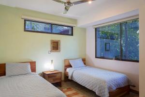 dwa łóżka w pokoju z dwoma oknami w obiekcie Casa Papaya - Eco Casita Phase 1-1 w mieście Iguana