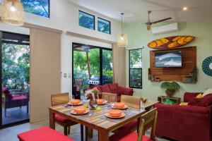 a living room with a wooden table and red chairs at Casa Papaya - Eco Casita Phase 1-1 in Iguana