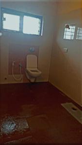 a bathroom with a toilet and a window at Coorg nest Home stay in Madikeri