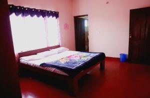 a bedroom with a bed in a room with a window at Coorg nest Home stay in Madikeri
