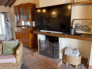 a living room with a fireplace with a large television at 2 King Bed, 2 Full Bathroom Apartment in Umbria - Tuscany in Città della Pieve