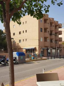 une moto garée devant un grand bâtiment dans l'établissement Formentera Es Pujols 2 camere vicinissimo alla spiaggia, à Es Pujols