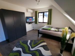 a small living room with a couch and a television at Ferienwohnung "Sanssouci", Mülheim Selbeck in Mülheim an der Ruhr