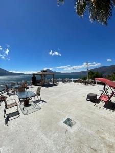 een groep tafels en stoelen op een strand bij Atitlan Inn in Jucanyá