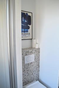 łazienka z toaletą i zdjęciem na ścianie w obiekcie Stunning last floor - Up to 5 P w Paryżu