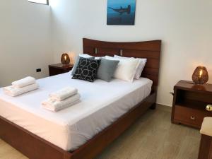 1 dormitorio con 1 cama con toallas en Suites en el paraíso San Cristóbal Galápagos, en Puerto Baquerizo Moreno