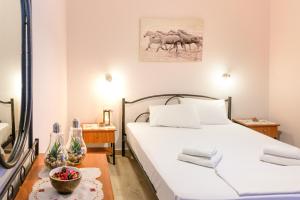 a bedroom with a bed and a picture of horses on the wall at Maria Rooms in Polychrono