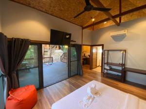 a living room with a bed and a large window at Cashewnut Cove in Ko Lipe