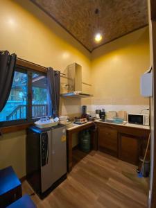 a small kitchen with a refrigerator and a counter at Cashewnut Cove in Ko Lipe