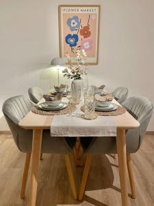 a dining room table with chairs and a table with flowers on it at Stadt-Oase - kostenlos Parken, ruhig, Kliniken, GOP, Bali-therme, Boxspringbett in Bad Oeynhausen