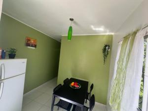 a kitchen with green walls and a table with a plate on it at Casa Vasquez in San Felipe de Puerto Plata