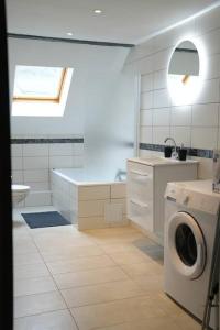 a white bathroom with a washing machine in it at Cocon du Florival in Guebwiller