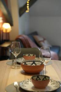 einem Holztisch mit zwei Gläsern und Körben darauf in der Unterkunft Cocon du Florival in Guebwiller