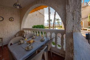 a dining room with a table and a balcony at Casa Vistamar Varadero in Santa Pola