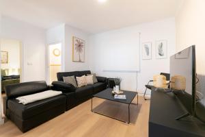 a living room with a black couch and a table at Casa DAURO in Granada