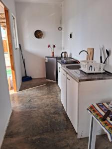 La cuisine est équipée d'un évier et d'un lave-vaisselle. dans l'établissement Cabañas de Punta Negra, à Punta Negra