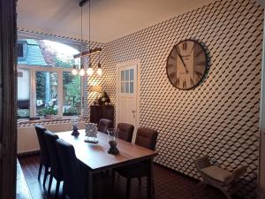 a dining room with a table and a clock on the wall at Couque cuivrée II in Dinant