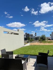 a patio with chairs and tables and a lawn at Lago Santa Ana in Santa Ana