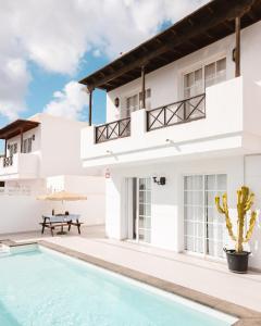 a villa with a swimming pool and a house at Villa Fariones in Tías