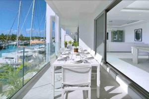 - une table à manger blanche sur un balcon avec vue sur les bateaux dans l'établissement New Luxury Waterfront Condo, Palm Cay, The Bahamas, à Nassau