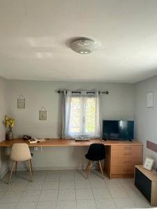 a desk in a room with a window and a desk with two chairs at Lofos house in Karavádhos