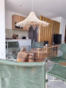 a dining room with a glass table and chairs at Refúgio a Poucos Passos do Mar l Milagres Hospedagens in Pôrto de Pedras