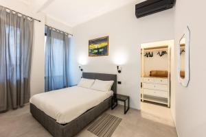 - une chambre avec un lit, une commode et un miroir dans l'établissement Boccadasse Chic Urban Retreat, à Gênes