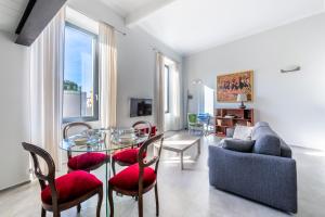 een woonkamer met een glazen tafel en stoelen bij Boccadasse Chic Urban Retreat in Genua