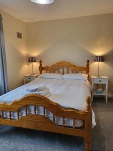 um quarto com uma cama de madeira e 2 candeeiros em Greenview em Ballysheedy