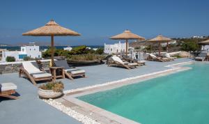 einen Pool mit Stühlen und Sonnenschirmen in einem Resort in der Unterkunft Anemoi Resort in Naoussa