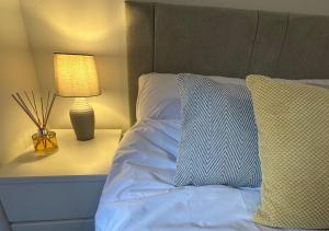 a bedroom with a bed with a lamp and pillows at Trendy West End Apartment, Glasgow in Glasgow