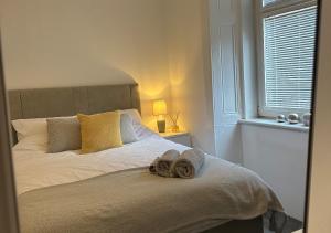 a bedroom with a bed with two towels on it at Trendy West End Apartment, Glasgow in Glasgow