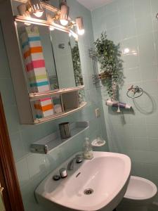 y baño con lavabo blanco y espejo. en Apartamento céntrico en Avilés