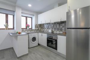 a kitchen with white cabinets and a refrigerator at El rincon de Mauro in Altea