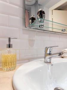 a bathroom sink with a soap dispenser and a mirror at Le Maçonnais - HYPER CENTRE MACON - PARKING GRATUIT - A 600m DE LA GARE in Mâcon