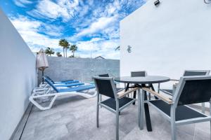 a patio with a table and chairs on a balcony at Casa Eva - Private Pool, BBQ & Free Parking By Lanzarote Vacation Homes in Los Pocillos +45 photos