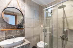 a bathroom with a sink and a shower at Olympus Pantheon Luxury Rooms in Plaka Litochorou