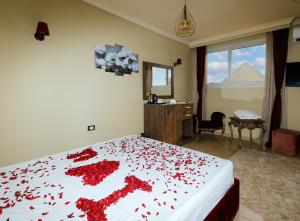 una camera con un letto ricoperto di petali di rosa rossa di Master Pyramids Inn a Il Cairo