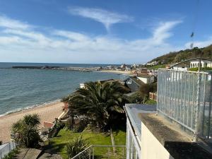 a view of the beach from the balcony of a house at High Tides in Lyme Regis