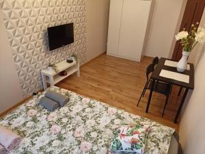 Pokój z łóżkiem, stołem i telewizorem w obiekcie Apartament GUNER w Bełchatowie