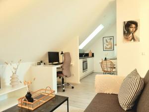 a living room with a couch and a desk at Homestay-Stylish, Zentral- Loft Apartment-Parking in Ingolstadt