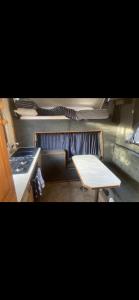 eine kleine Küche mit einem Tisch und einem Herd in der Unterkunft Hunter the Horsebox in Henley on Thames