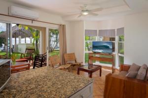 a kitchen and living room with a couch and a tv at Villas Iguana A-13 Beachfront Condo in Iguana