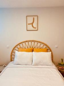 een slaapkamer met een bed met witte lakens en oranje kussens bij Penagoda Beach House in Espinho