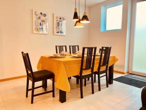 een eetkamer met een gele tafel en stoelen bij Penagoda Beach House in Espinho