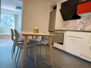 a kitchen with a wooden table and some chairs at Center, Sauna - Haus LINARIA in Leukerbad