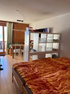 1 dormitorio con 1 cama grande y comedor en "Le Ptit Nid" studio avec vue à couper le souffle à Leysin !, en Leysin