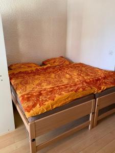 1 cama con edredón naranja en una habitación en "Le Ptit Nid" studio avec vue à couper le souffle à Leysin !, en Leysin